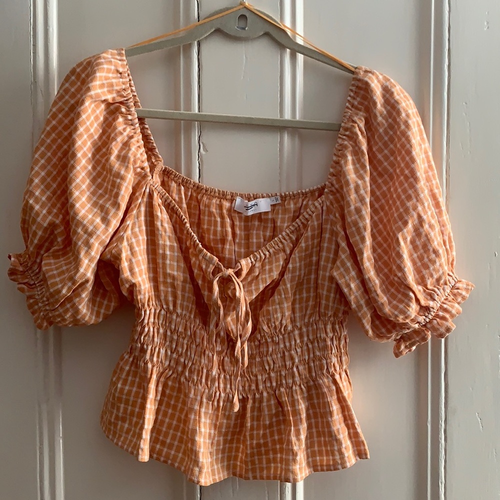 Orange and white crop top with balloon sleeves.